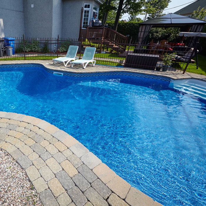 pool with patio and lounge chairs