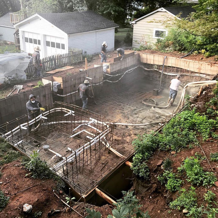 team working on empty pool build site